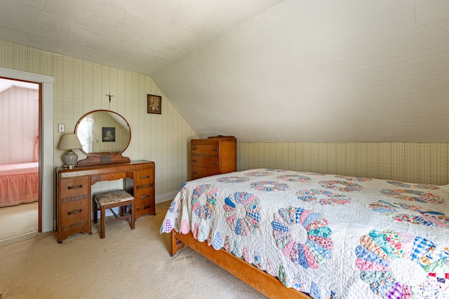 carpeted bedroom with vaulted ceiling, a textured ceiling, and wallpapered walls