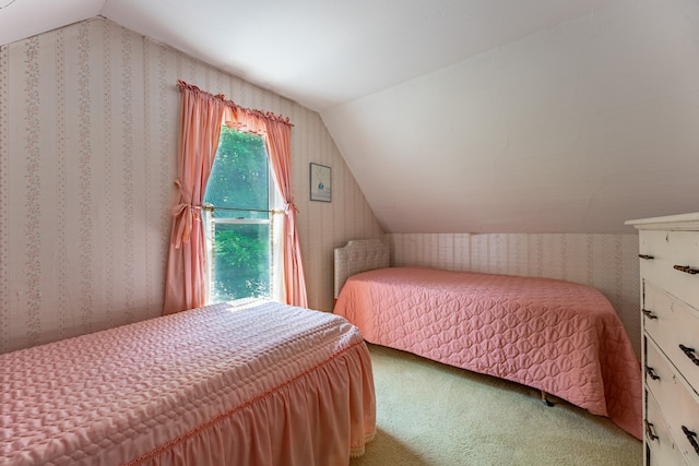 bedroom featuring vaulted ceiling, carpet flooring, and wallpapered walls