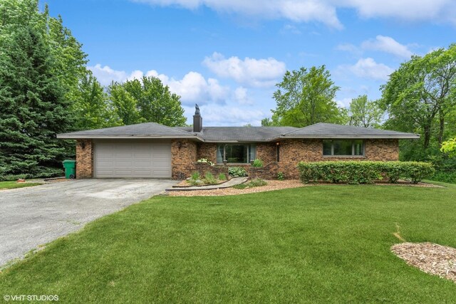 single story home with a garage and a front lawn