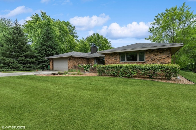 ranch-style house with an attached garage, concrete driveway, brick siding, and a front yard