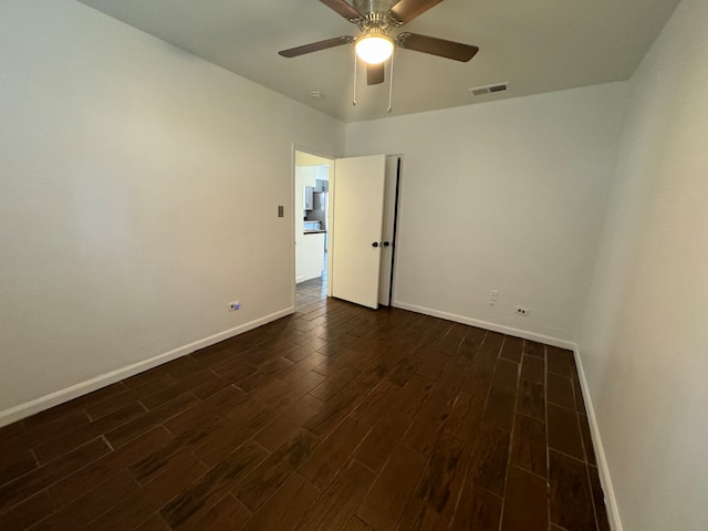 empty room featuring ceiling fan and dark wood-type flooring