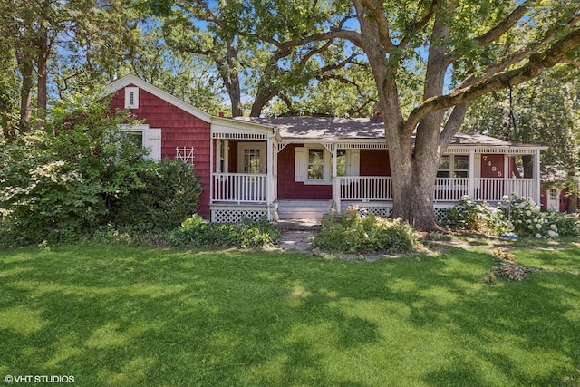 ranch-style home featuring covered porch and a front lawn