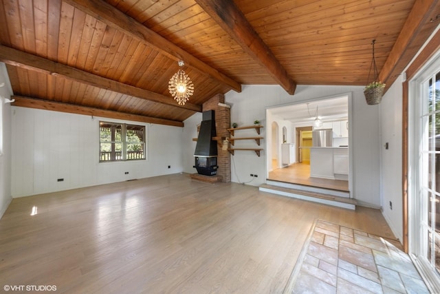 unfurnished living room with a notable chandelier, light hardwood / wood-style floors, wood ceiling, and vaulted ceiling with beams