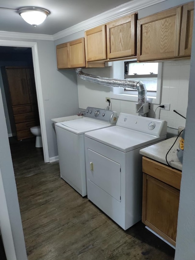 laundry area with washing machine and clothes dryer, sink, cabinets, ornamental molding, and dark hardwood / wood-style floors