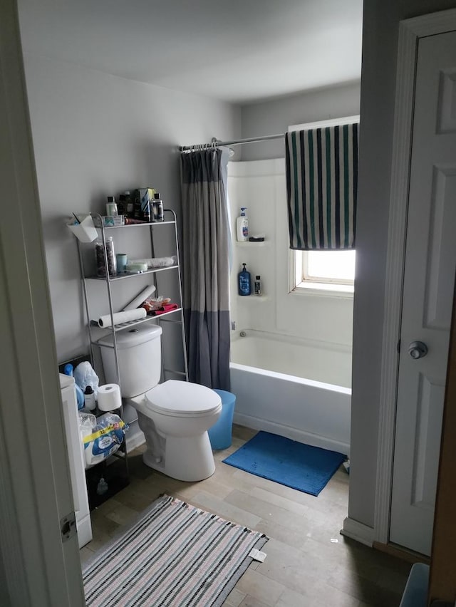 bathroom featuring hardwood / wood-style floors, shower / tub combo, and toilet