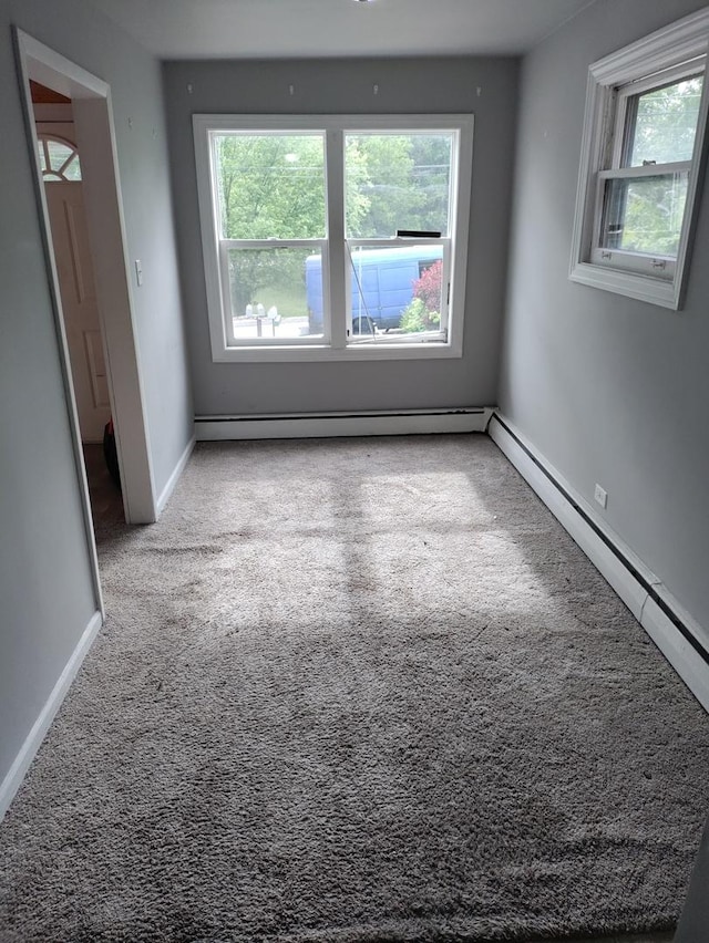 unfurnished room with a baseboard radiator and light colored carpet