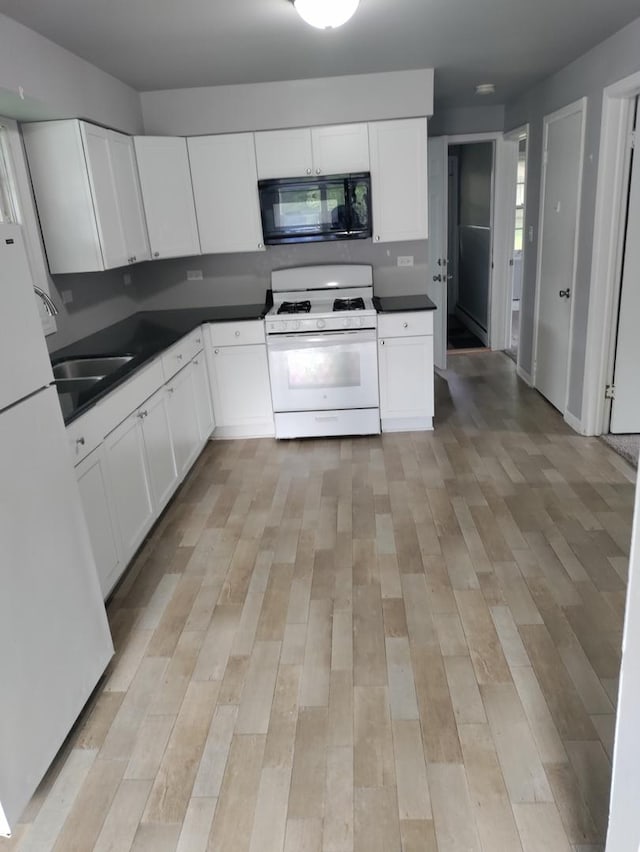 kitchen with white appliances, light hardwood / wood-style floors, and white cabinets