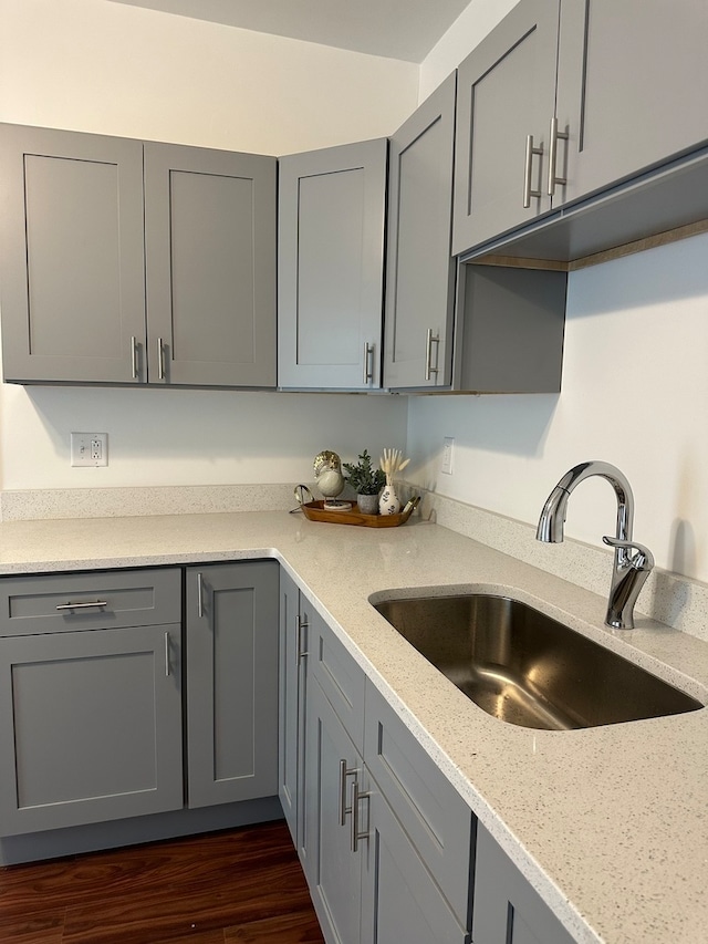 kitchen featuring gray cabinets, dark wood-type flooring, and sink