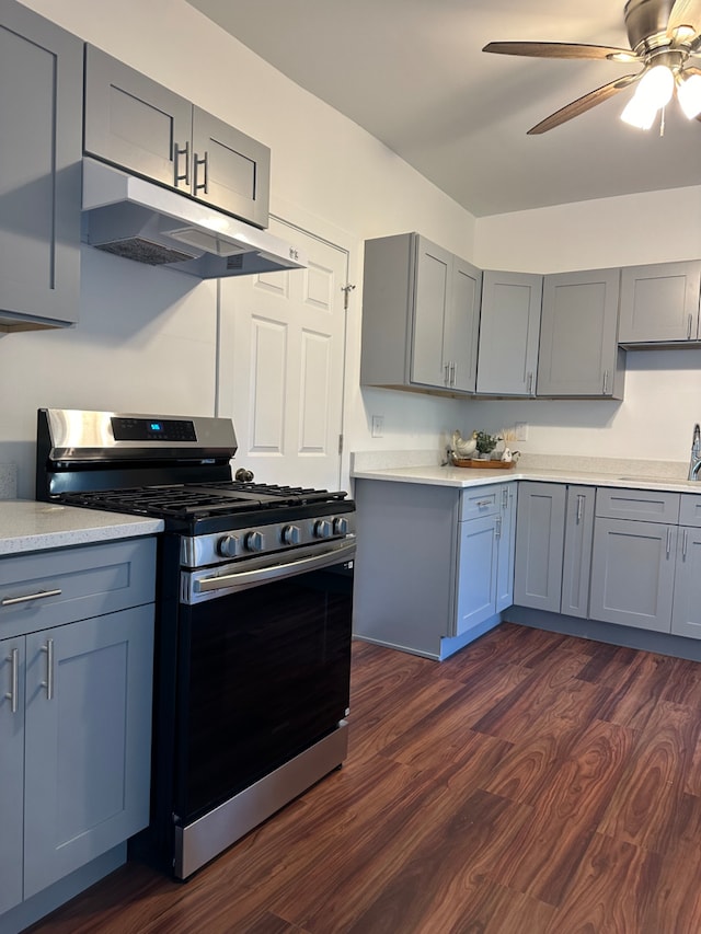 kitchen with gray cabinets, ceiling fan, dark hardwood / wood-style floors, and stainless steel gas range