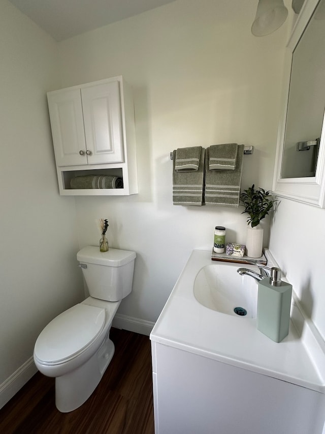 bathroom with hardwood / wood-style floors, vanity, and toilet