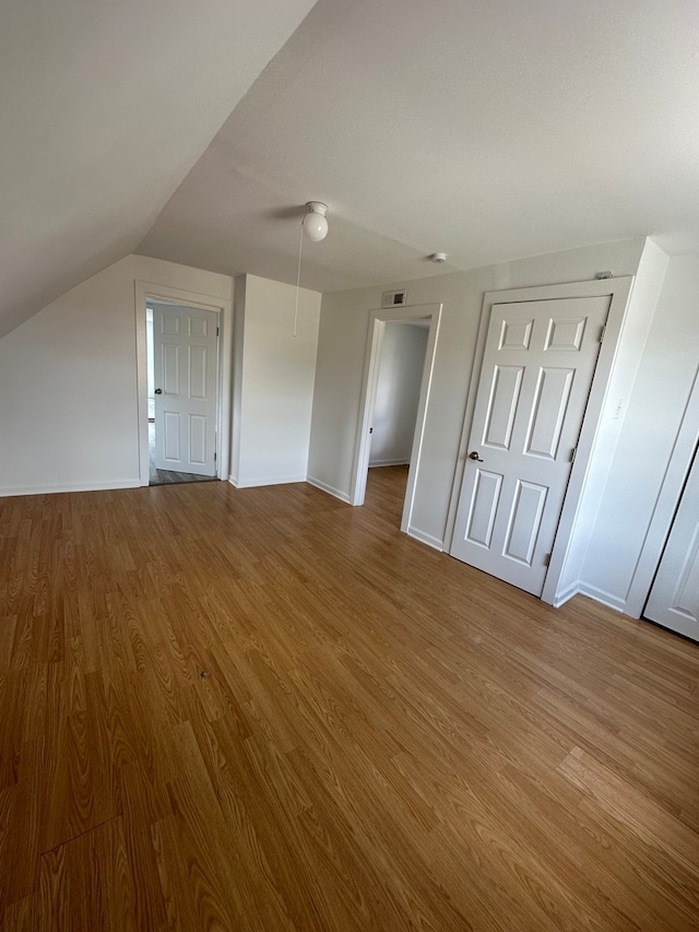 additional living space with lofted ceiling and wood-type flooring