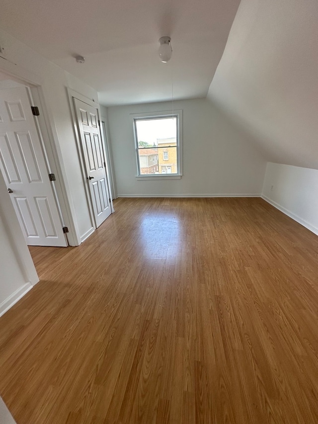 bonus room featuring vaulted ceiling and light wood-type flooring