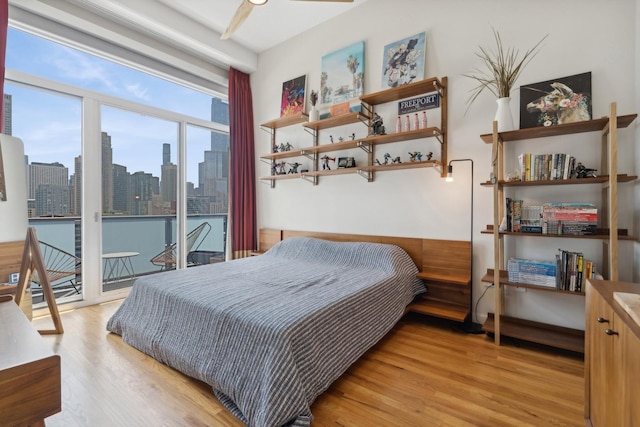 bedroom with ceiling fan, access to exterior, and light hardwood / wood-style flooring