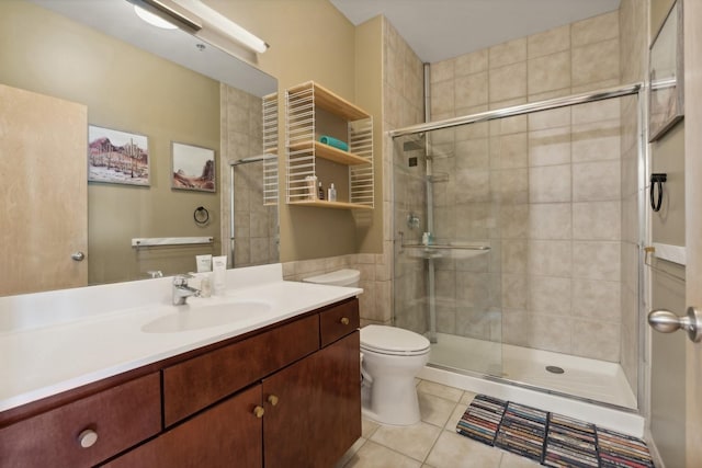 bathroom featuring tile patterned floors, a shower with door, vanity, and toilet