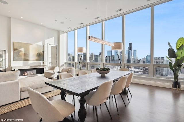 dining area featuring a wealth of natural light, dark wood-type flooring, and expansive windows