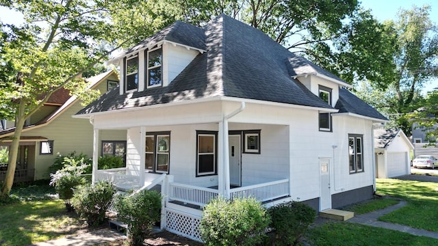 exterior space featuring a porch, a garage, and a front yard