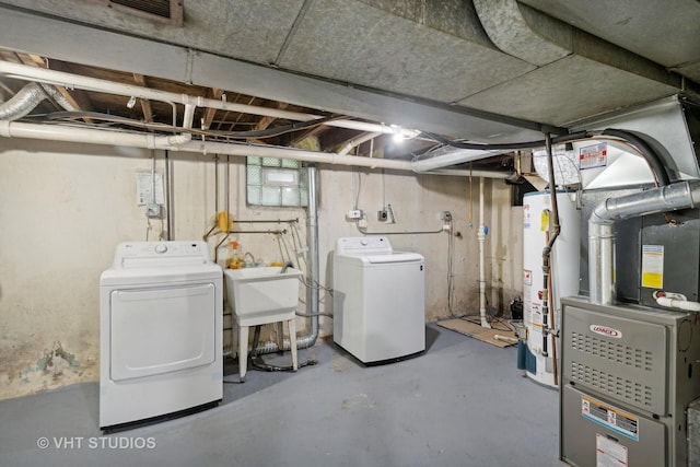 basement with sink, gas water heater, and washer and dryer