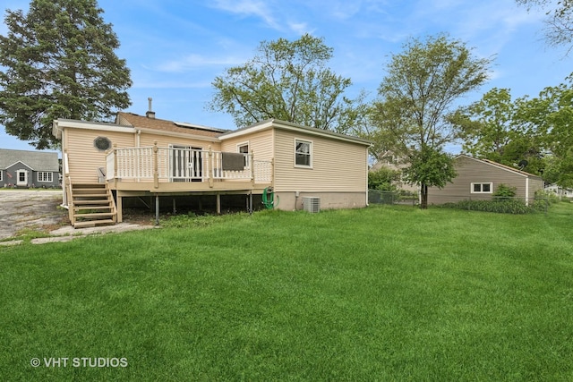 rear view of house with a yard, a deck, and central AC