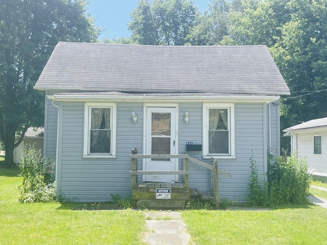 bungalow-style home featuring a front lawn