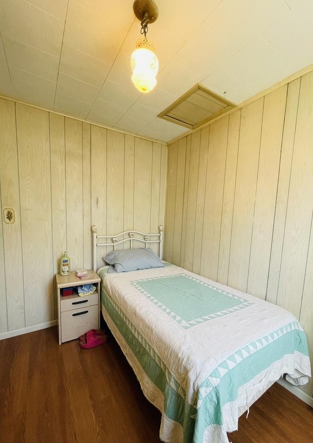 bedroom featuring dark hardwood / wood-style flooring and wood walls