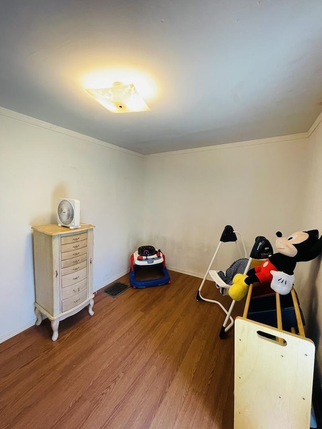 miscellaneous room with crown molding and wood-type flooring