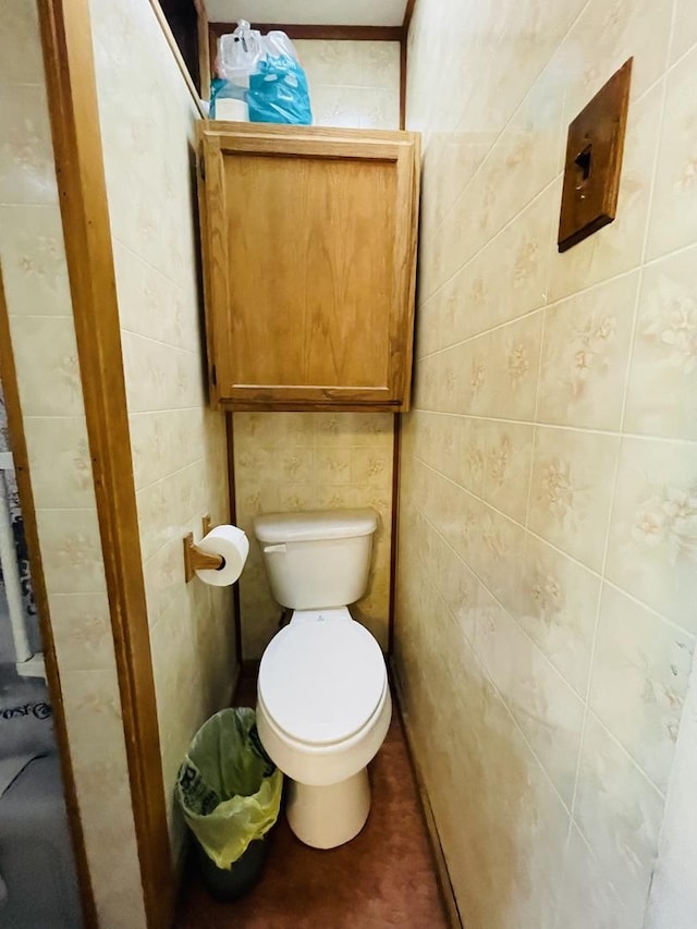 bathroom featuring toilet, tile walls, and ornamental molding