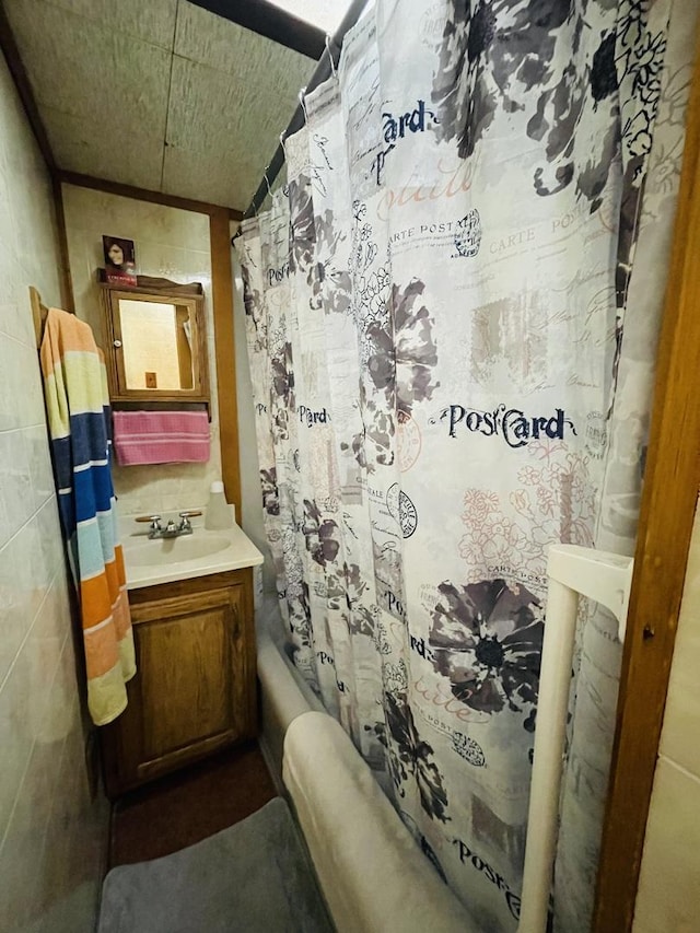 bathroom featuring shower / bathtub combination with curtain and sink