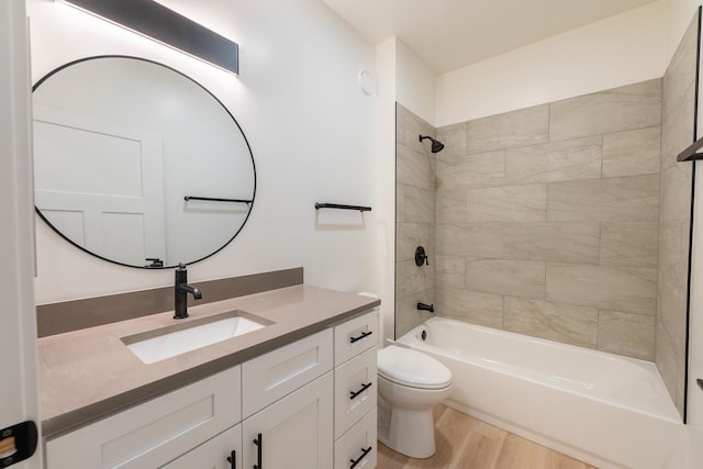 full bathroom with vanity, hardwood / wood-style flooring, toilet, and tiled shower / bath