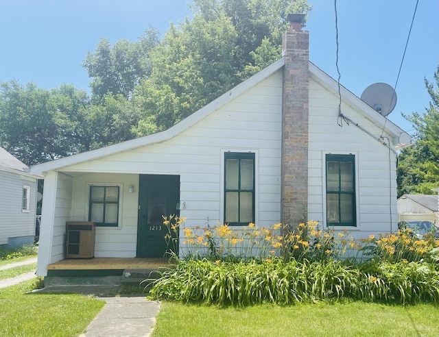 exterior space with covered porch and a front lawn