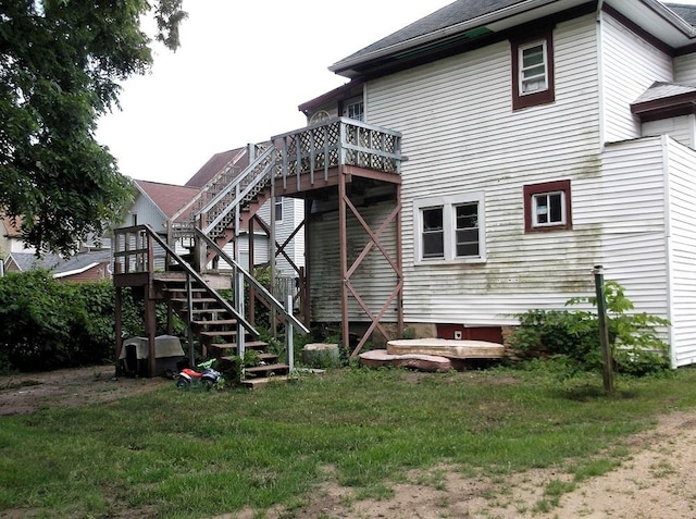 rear view of property with a wooden deck and a yard