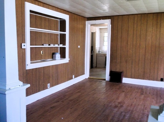 spare room featuring dark hardwood / wood-style floors and wood walls