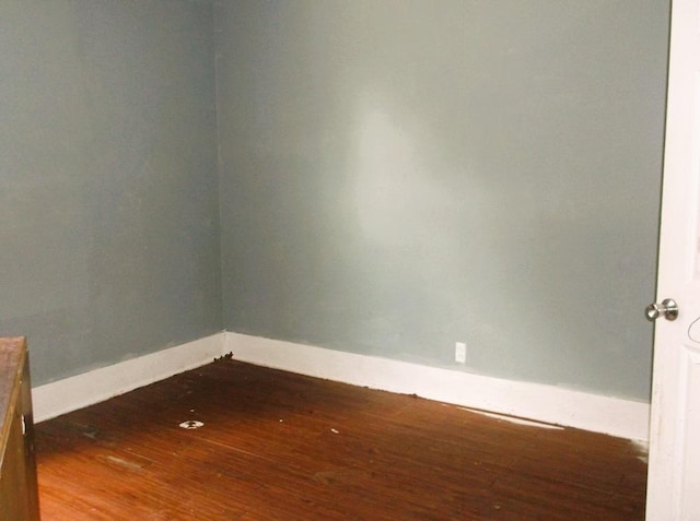 unfurnished room with dark hardwood / wood-style flooring