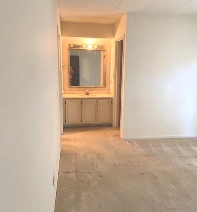 corridor with sink and light carpet