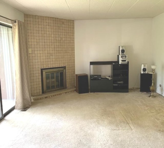 unfurnished living room featuring carpet floors and a fireplace