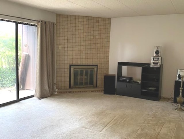 unfurnished living room with light colored carpet and a tile fireplace