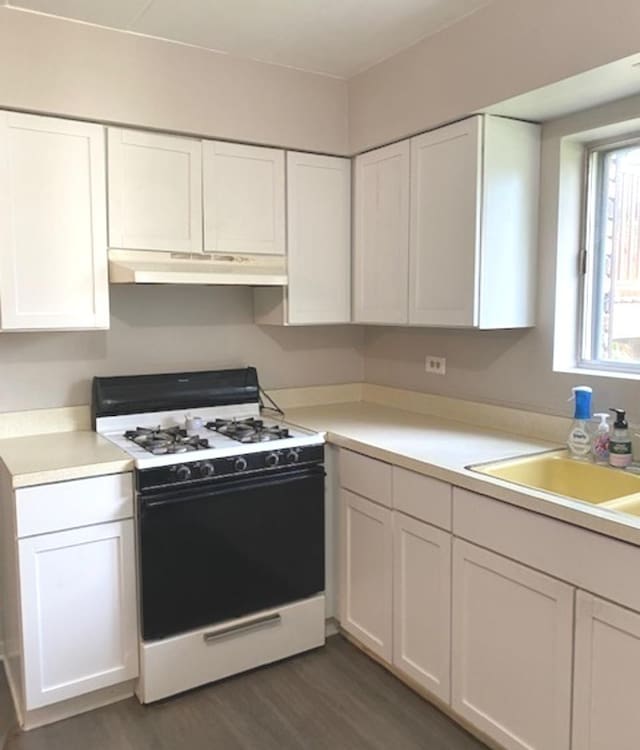 kitchen featuring dark wood-type flooring, white cabinetry, white range with gas cooktop, and sink