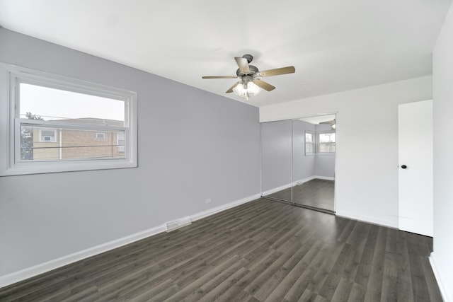 unfurnished bedroom with ceiling fan, dark hardwood / wood-style flooring, and a closet