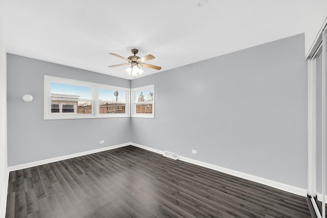 unfurnished room featuring dark hardwood / wood-style floors and ceiling fan