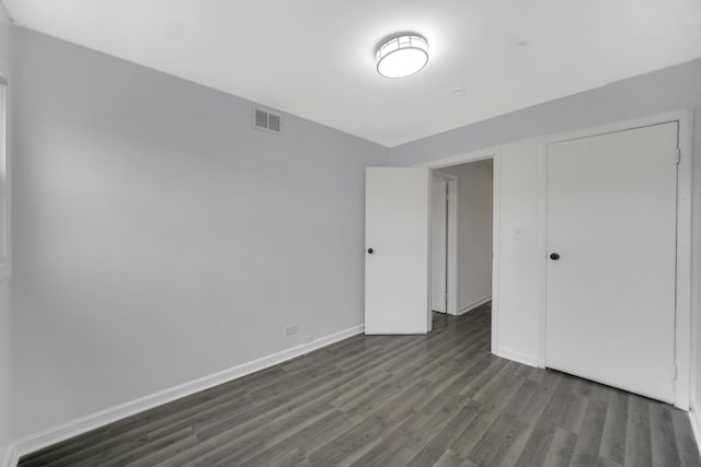 unfurnished bedroom featuring dark hardwood / wood-style floors