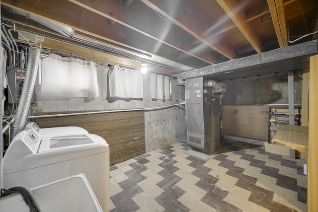 basement featuring washing machine and dryer and heating unit