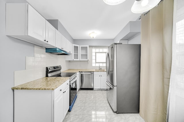 kitchen with decorative backsplash, stainless steel appliances, white cabinetry, and sink