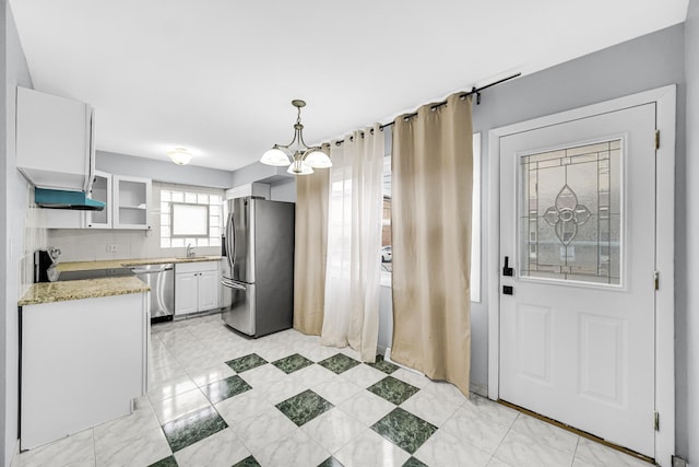 kitchen with pendant lighting, an inviting chandelier, white cabinets, sink, and stainless steel appliances