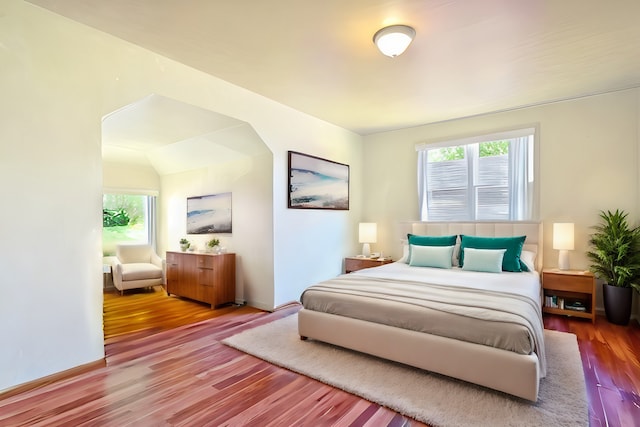 bedroom with multiple windows and hardwood / wood-style floors