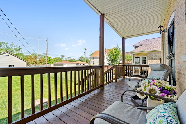 wooden terrace featuring a lawn