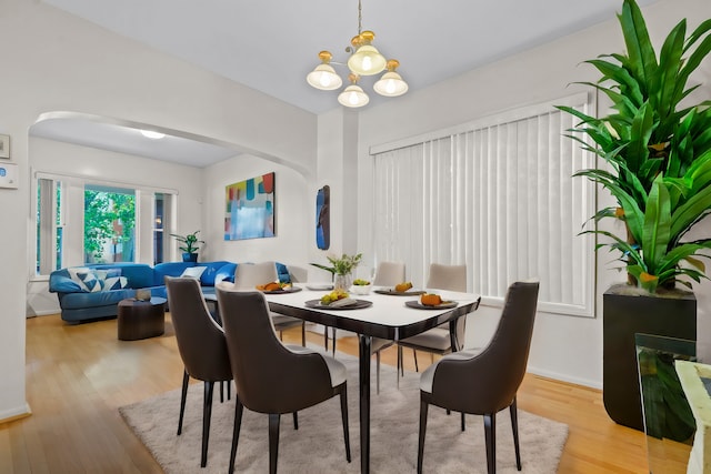 dining space with light hardwood / wood-style flooring and a notable chandelier