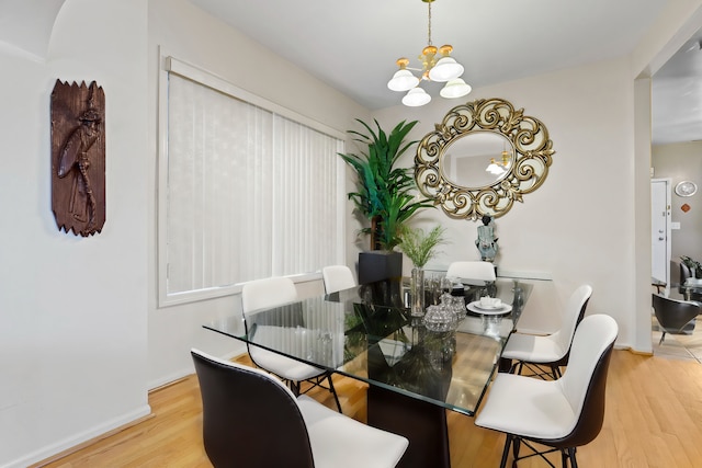 dining room with hardwood / wood-style flooring and a notable chandelier