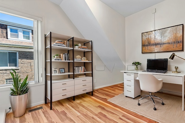 office space featuring lofted ceiling and light hardwood / wood-style floors