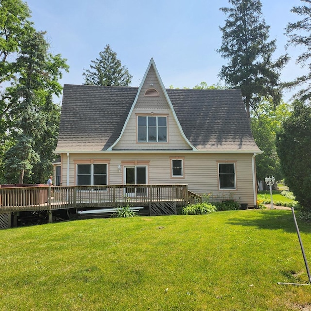 rear view of property featuring a yard and a deck