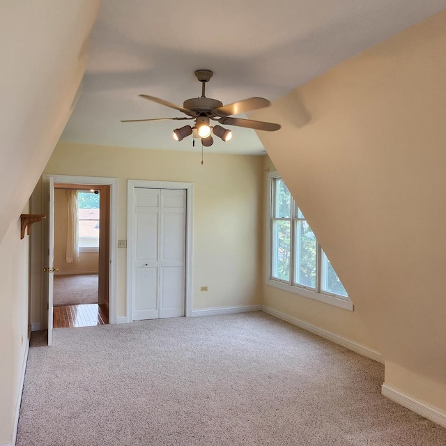 additional living space featuring ceiling fan, light carpet, and vaulted ceiling