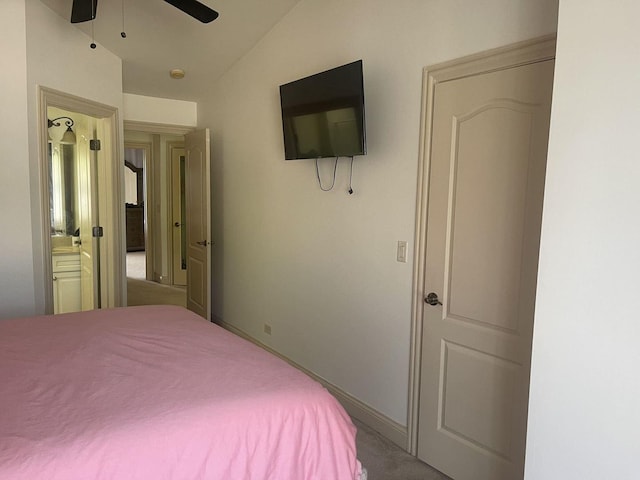 bedroom featuring carpet flooring, ensuite bath, ceiling fan, and vaulted ceiling